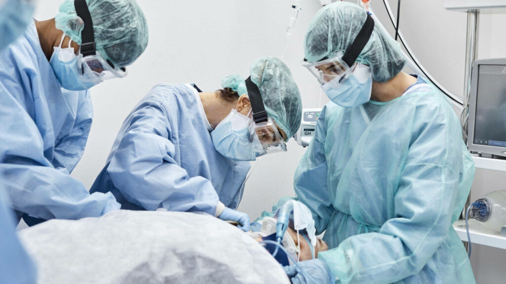 Life-Savers in Action: Surgeon Team Conducting Critical Operation in ICU Ambiance Wallpaper