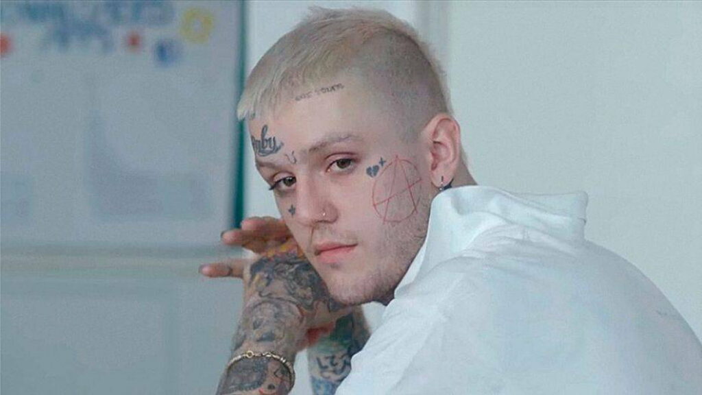 Lil Peep's Tattooed Transformation: A Unique Fashion Statement in Dreamy Blur Background Wallpaper