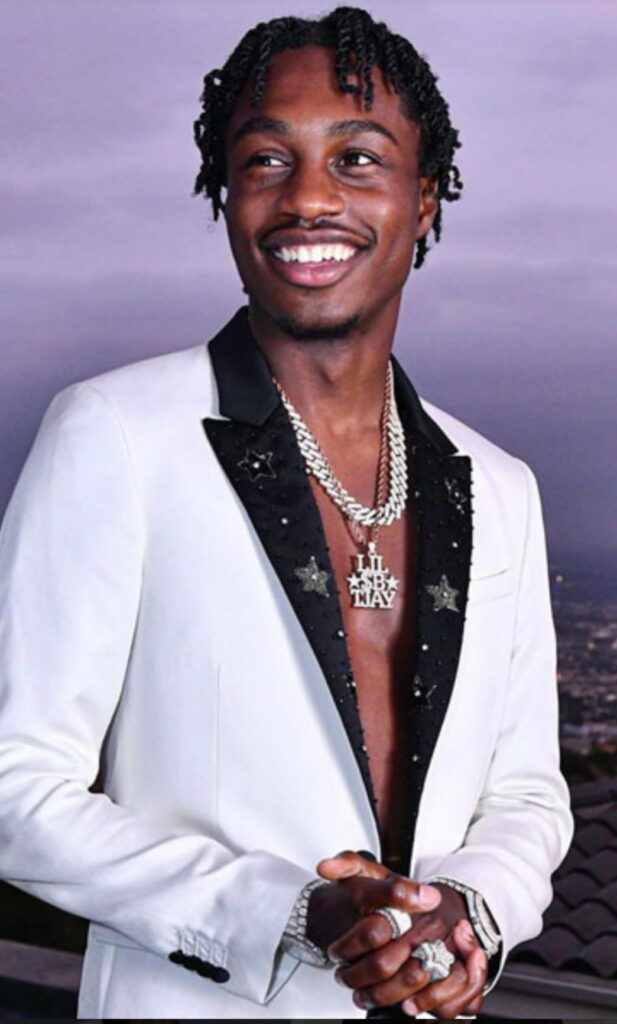 Lil Tjay beaming with a radiant smile on a stunning HD phone wallpaper