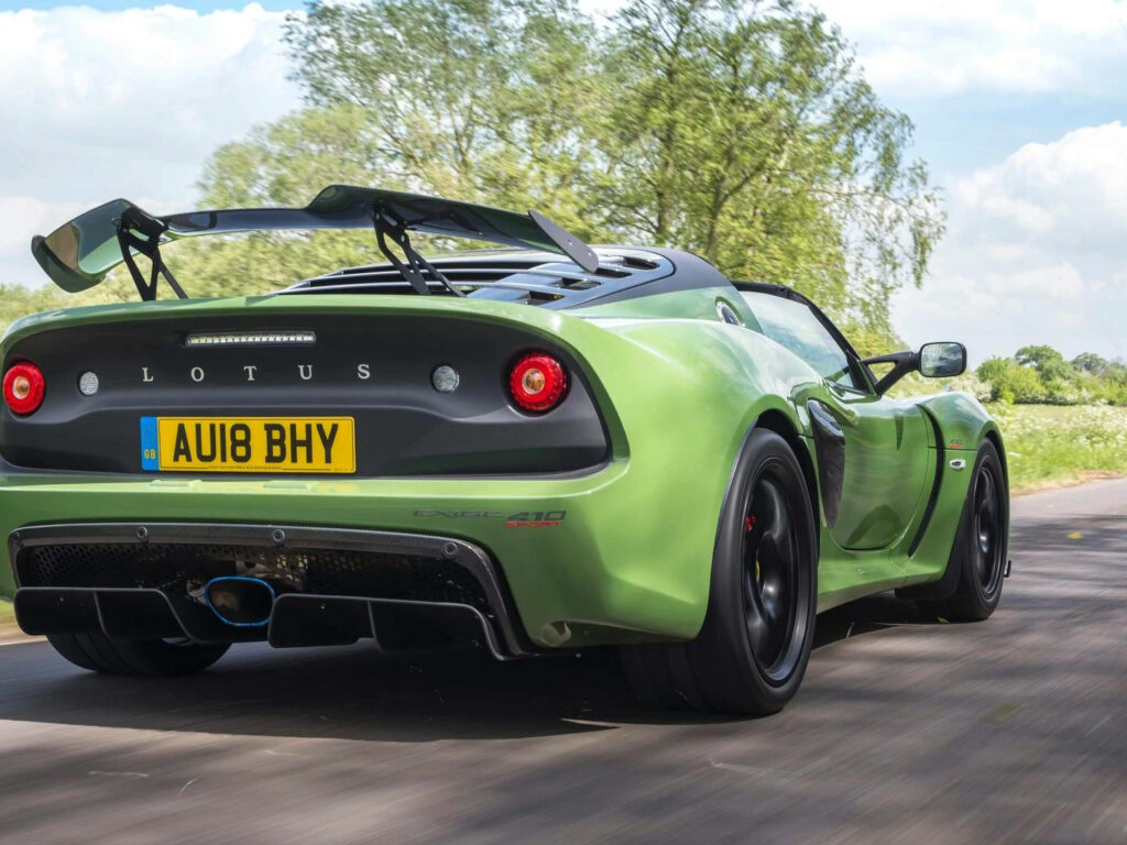 Limited edition Lotus rear view with prominent spoiler racing on scenic countryside road wallpaper