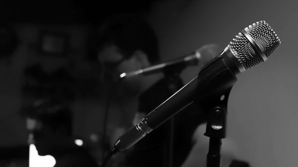 Dynamic Black and White Music Wallpaper: Mic Focus with Musicians