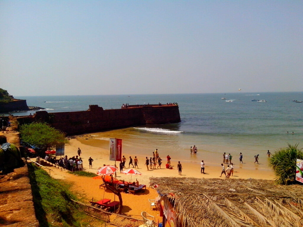 Goa Beach Scene: Vibrant Shoreline & Historic Fort Wallpaper