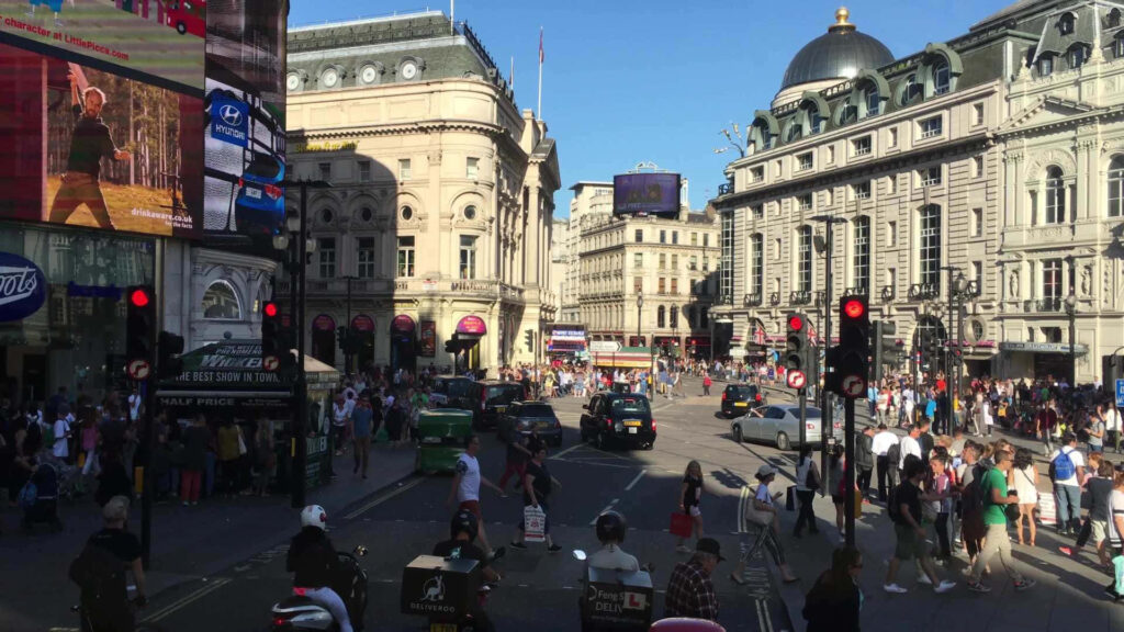 Vibrant Piccadilly Circus Scene: Busy London Road & Iconic Architecture Wallpaper
