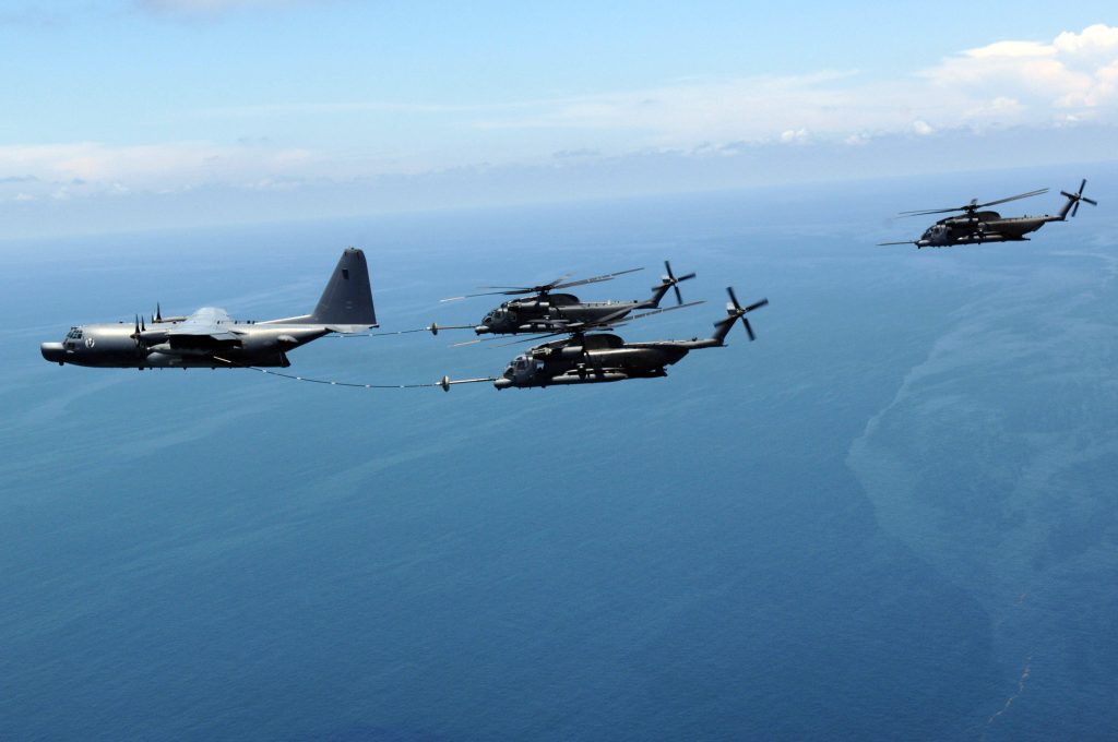 Lockheed C-130 tanker refueling Sikorsky CH-53 helicopters in formation over ocean wallpaper