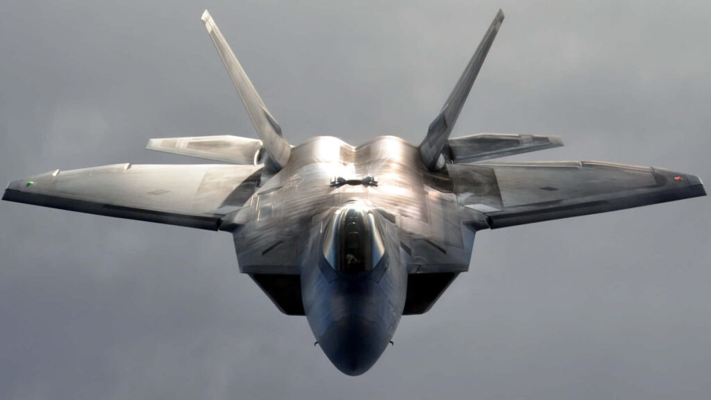 Lockheed Martin F-22 Raptor close-up showing sleek stealth design and metallic gray finish flying Wallpaper