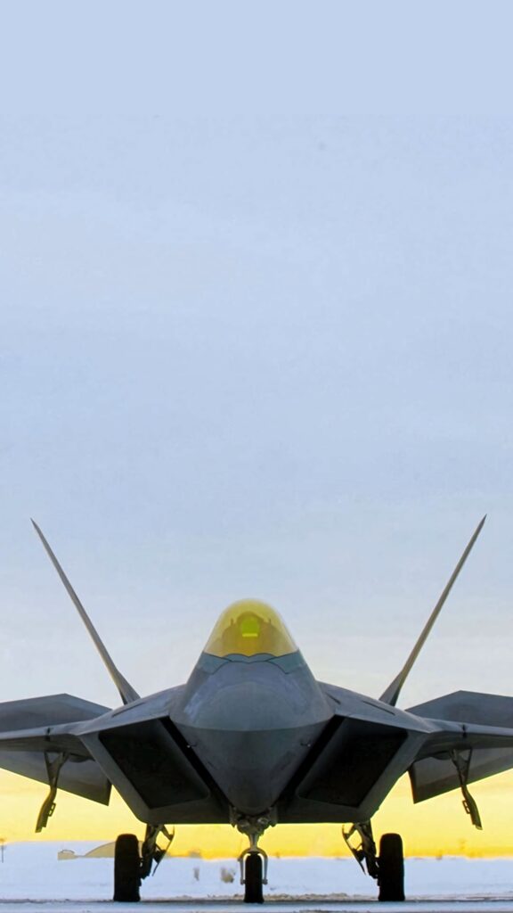 Lockheed Martin F-22 Raptor front view with gold canopy and sleek stealth design in blue sky Wallpaper