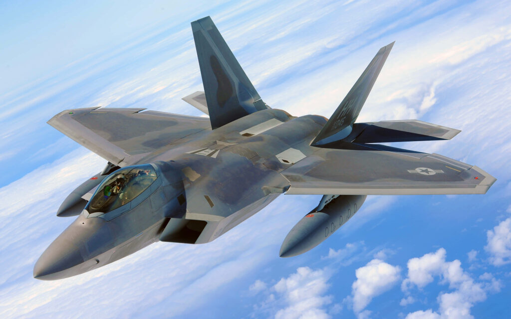 Lockheed Martin F-22 Raptor stealth fighter jet flying above clouds with modern gray camo Wallpaper