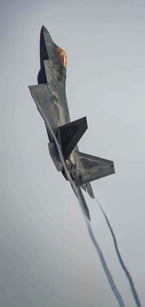 Lockheed Martin F-22 Raptor soaring vertically with sleek stealth design and metallic gray camouflage Wallpaper