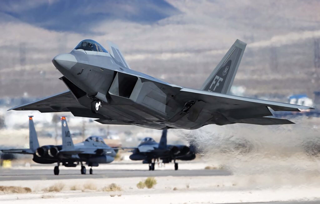 Lockheed Martin F-22 Raptor taking off from desert airbase showcasing sleek stealth design Wallpaper