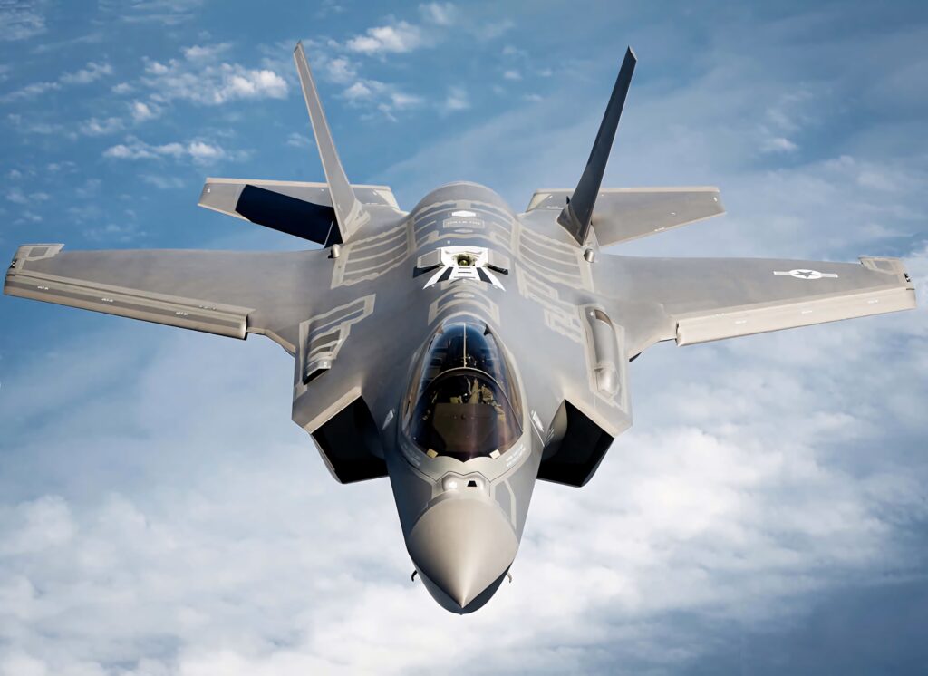 Lockheed Martin F-35 stealth fighter jet soaring above clouds with sharp gray camo details Wallpaper