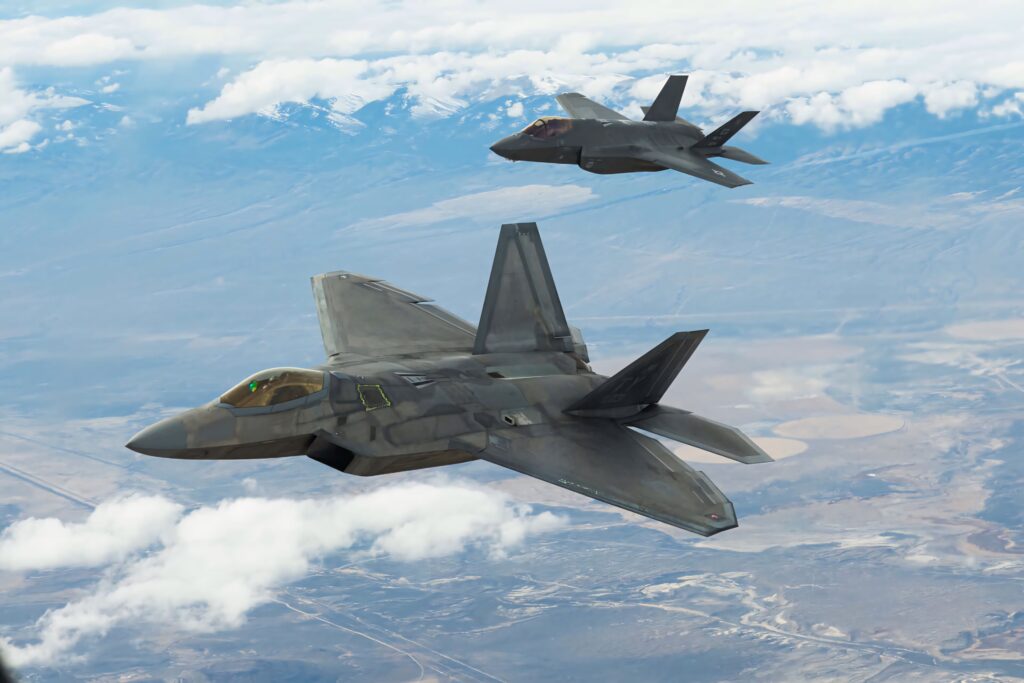 High-resolution wallpaper of two Lockheed Martin F-35 fighter jets soaring over mountains and clouds