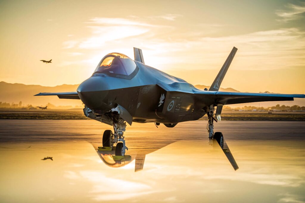 Lockheed Martin F-35 stealth fighter jet on runway at sunset with golden light reflection wallpaper