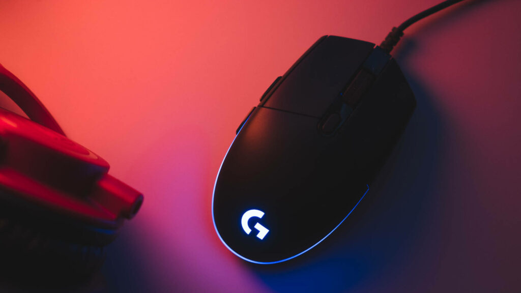 Logitech gaming mouse glowing neon lights on pink and orange tech-inspired wallpaper background