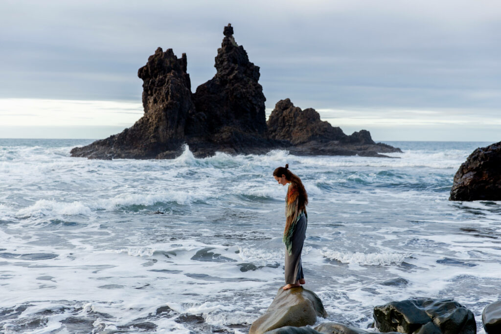Solitary Conquest: A Lone Adventurer Embracing Serenity on Remote Coastal Cliffs Wallpaper