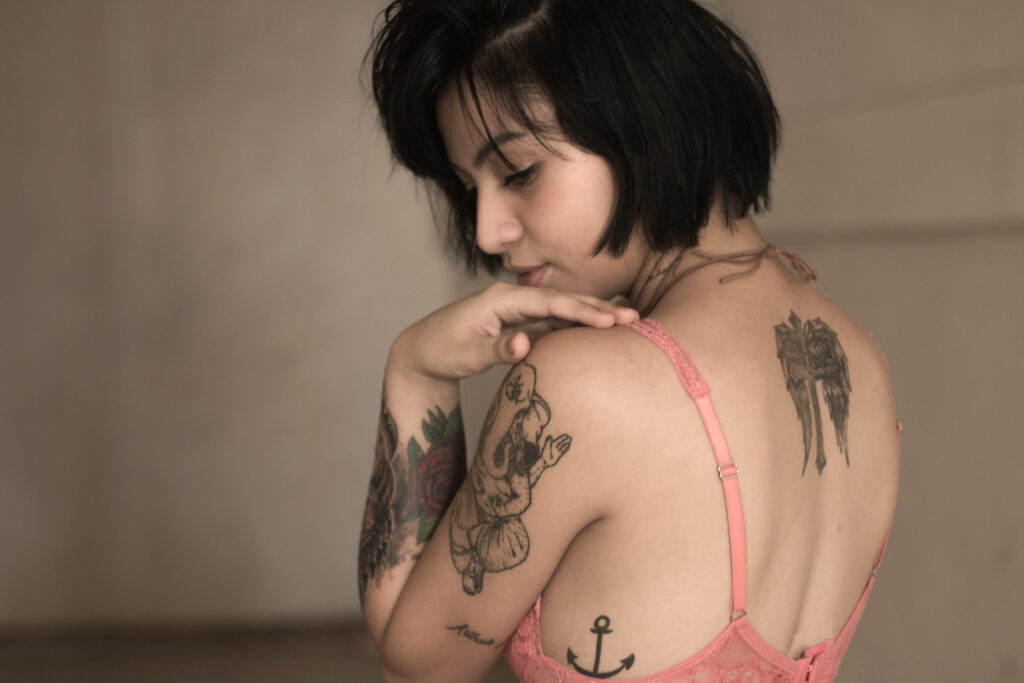 Lonely Femme Fatale: A Melancholic Portrait of a Tattooed Lady in Pink Wallpaper