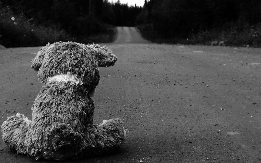 Loneliness Lingers: A Gloomy Snapshot of a Desolate Teddy Bear Amidst a Desolate Landscape Wallpaper