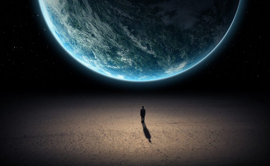 Solitude in Space: A Man Stands Alone in the Universe Against Earth's QHD Wallpaper