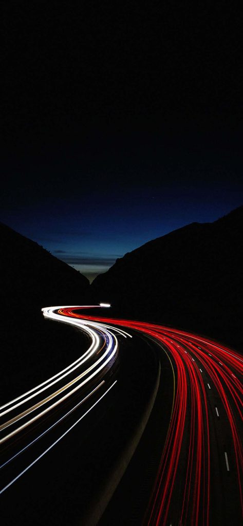 Long exposure highway light trails at night with mountains and twilight sky minimalist wallpaper
