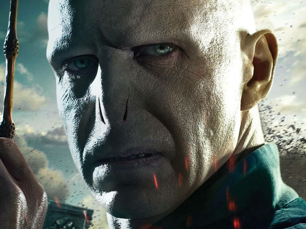 Close-up 3D wallpaper of Lord Voldemort with intense snake features and piercing blue eyes
