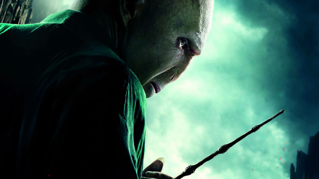 Lord Voldemort under glowing green night sky holding wand with menacing intense presence wallpaper
