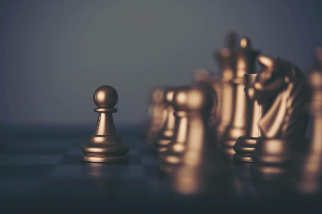Lost Glory: A Striking Display of Chess Pieces on Faded Gray Wallpaper