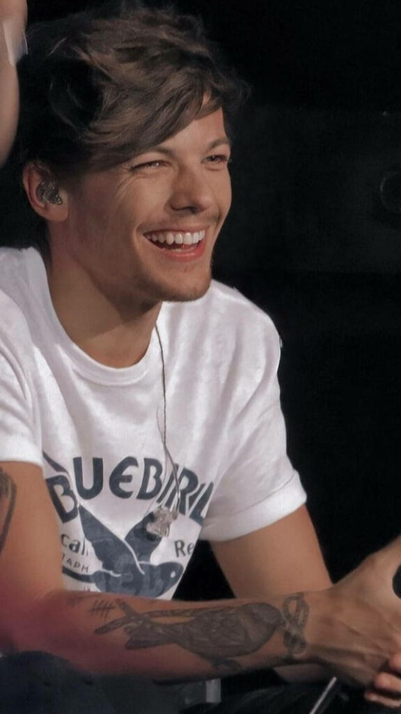 Radiant Louis Tomlinson: Captivating in White, Embracing the Mic Wallpaper