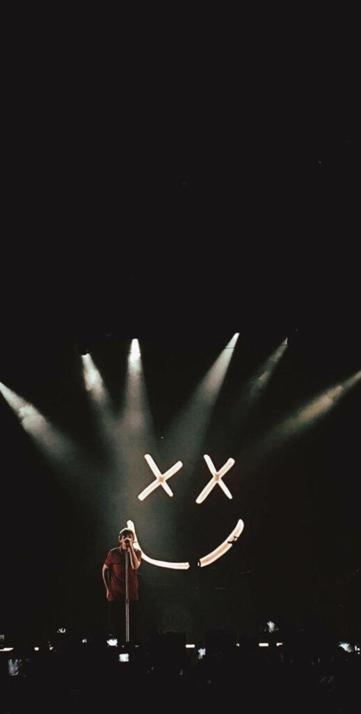 Fierce Spotlight: Louis Tomlinson electrifies the stage with an infectious smile amidst a captivating concert backdrop Wallpaper