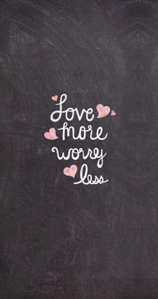 Chalkboard wallpaper with Love more worry less phrase in white pink chalk and hearts design