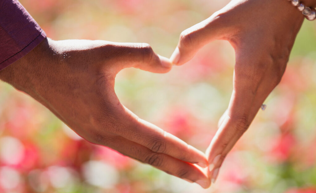 Romantic Gesture: Couple Hands Creating Heart Shape in a Lovely Background Photo Wallpaper