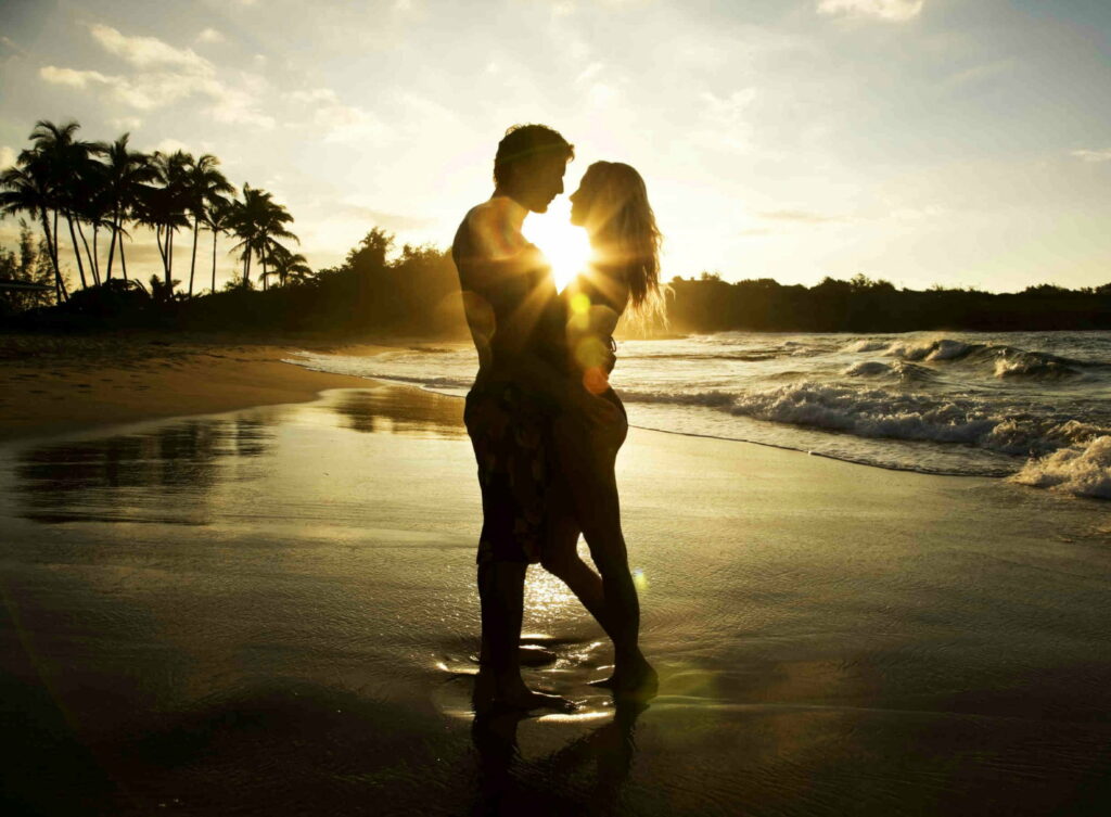 A Serene Beach Encounter: A Promise of Love's Bliss at Sunset Wallpaper