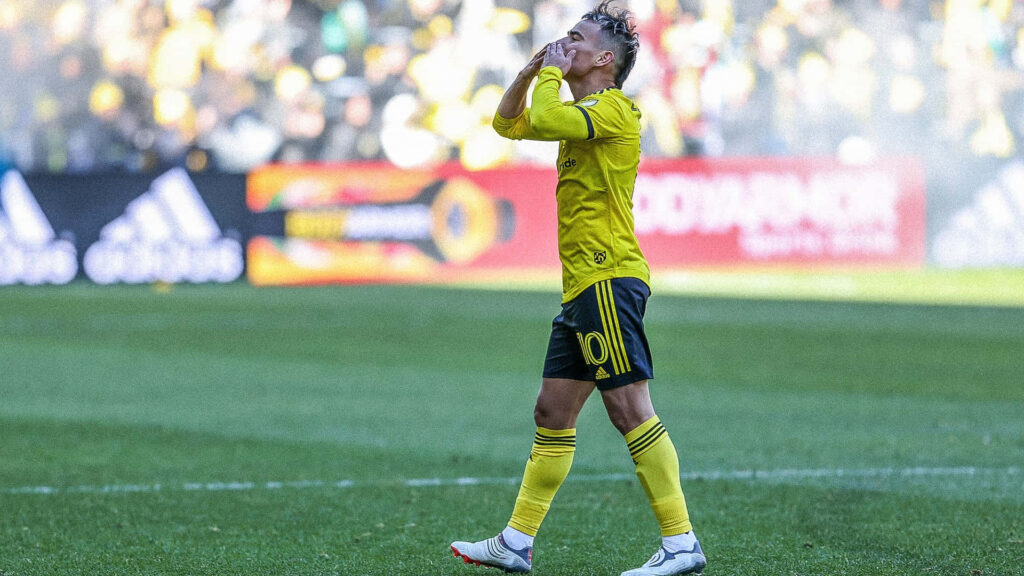 Lucas Zelarayan Columbus Crew celebrating in bright yellow kit during intense soccer match wallpaper