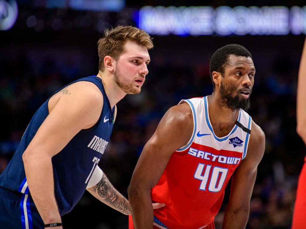 Luka Doncic of Dallas Mavericks defends Harrison Barnes Sacramento Kings in intense NBA game Wallpaper