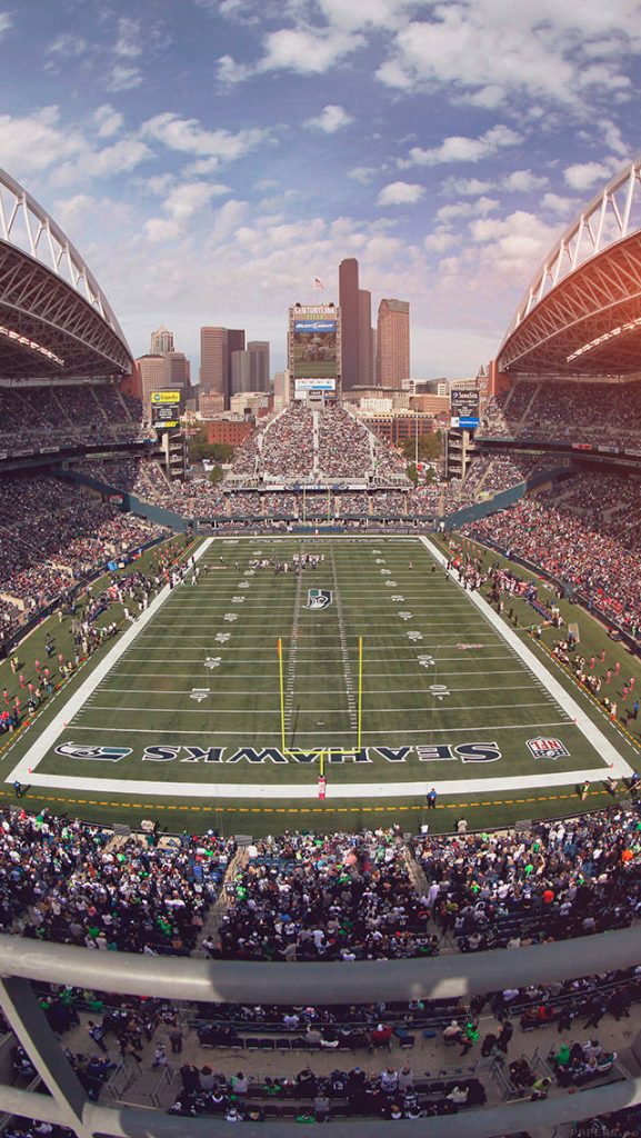 Wide-angle Lumen Field stadium with Seattle Seahawks fans and city skyline at game day Wallpaper