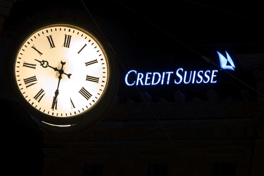Luminous Roman numeral clock and glowing Credit Suisse logo at night with elegant cityscape lighting Wallpaper
