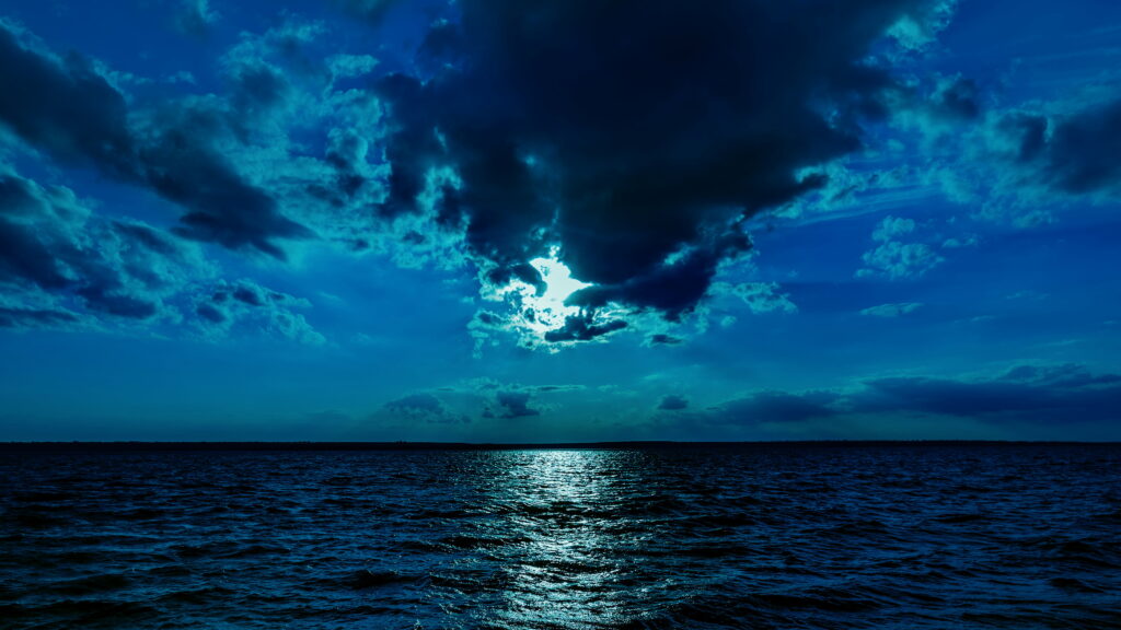 Luminous Night: A Breathtaking Moonlit Sky Over the Serene Blue Sea Wallpaper