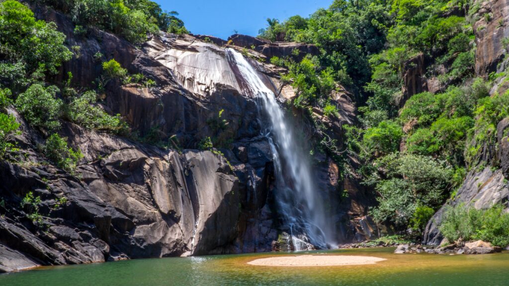 Waterfall cascading rugged cliffs lush greenery São Paulo Brazil clear skies serene pool wallpaper