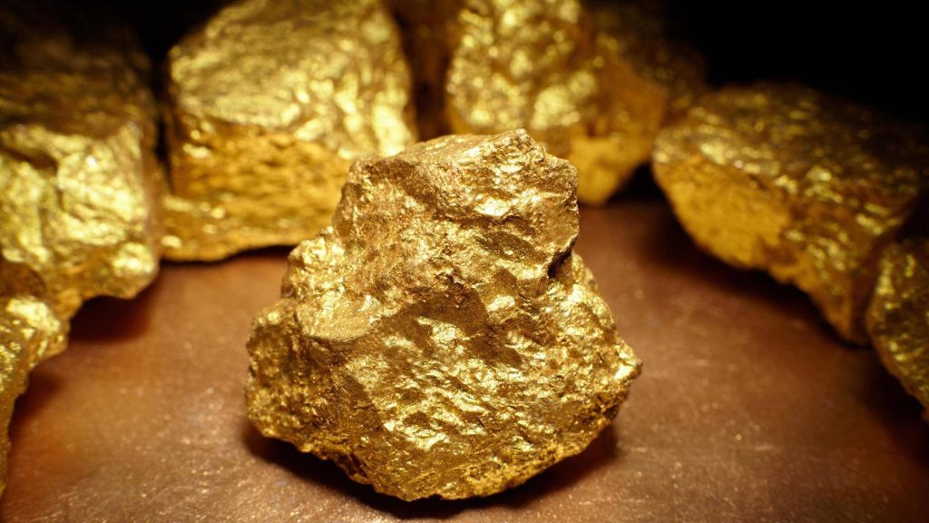 Macro close-up of raw gold nuggets with warm metallic lighting for wealth desktop wallpaper