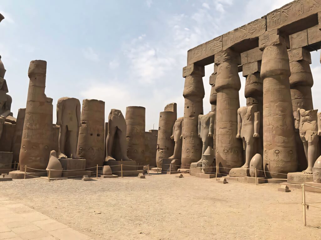 Evening view of Luxor Temple stone columns with ancient hieroglyphics in warm sunlight wallpaper