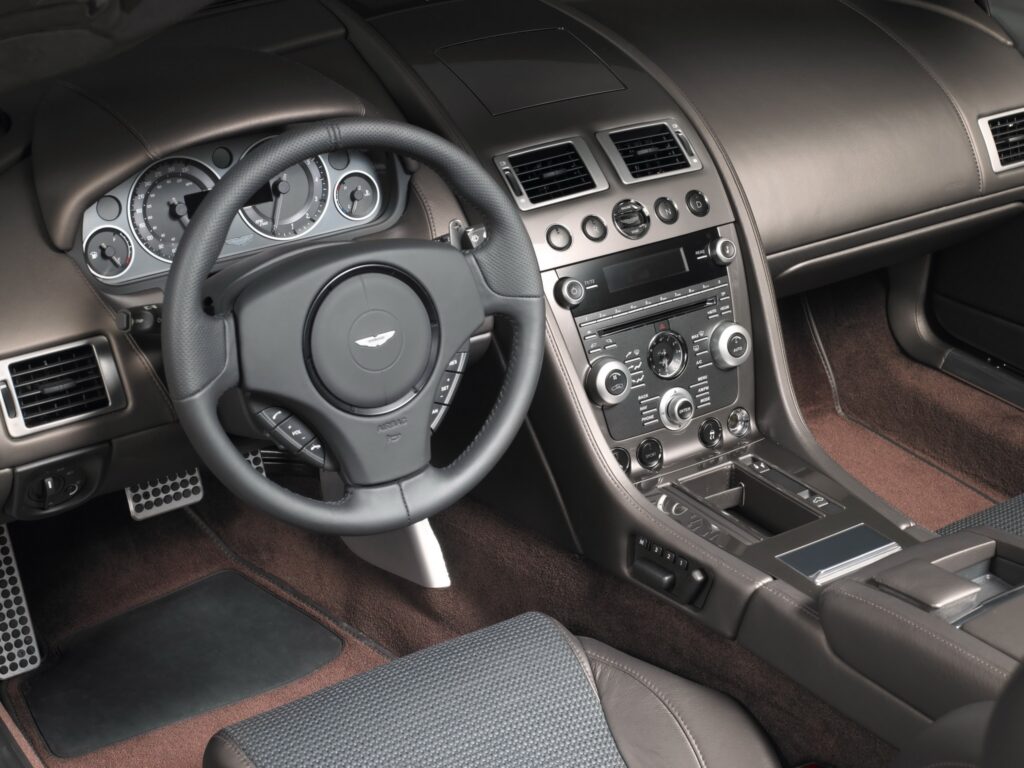 Luxurious 2010 Aston Martin DBS Interior: Elegant Steering Wheel & Speedometer Wallpaper