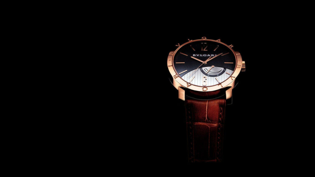 Luxurious Bvlgari watch with brown leather strap and gold casing on black background wallpaper