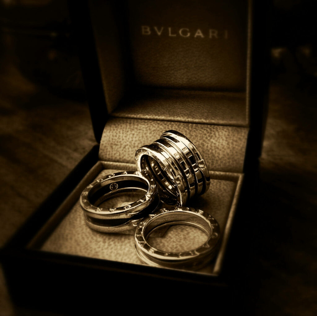 Bvlgari rings in branded box with warm sepia tones highlighting intricate designs and shine Wallpaper
