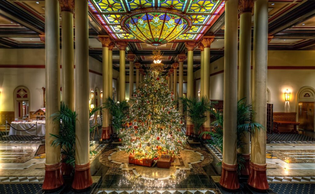 Elegant Christmas Hall with Stunning Tree & Stained-Glass Ceiling Wallpaper