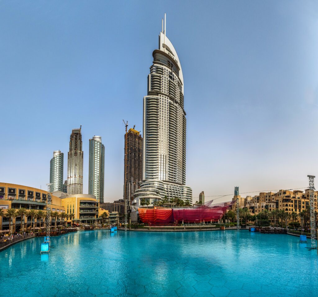 Luxurious Dubai Skyscraper Hotel Wallpaper with Serene Pool Reflection