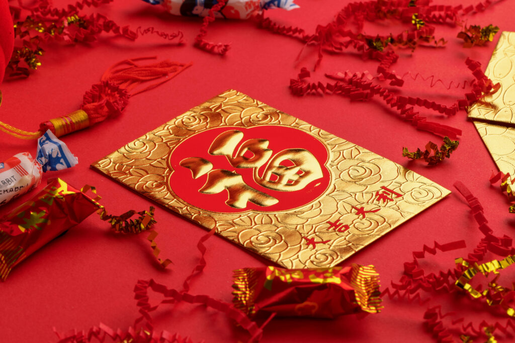 Luxurious gold lucky envelope with floral patterns on red background for Chinese New Year prosperity Wallpaper