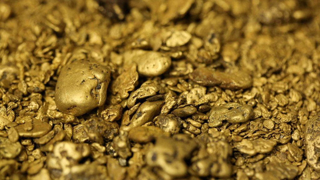 Macro close-up of natural gold nuggets and flakes with detailed warm metallic textures wallpaper