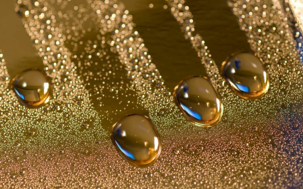 Luxurious Golden Wallpaper: Reflective Drops & Glimmering Crumbs