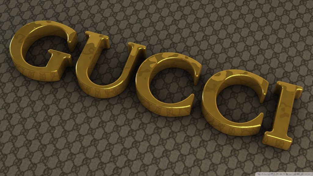 Gucci wallpaper with 3D gold logo and brown GG monogram pattern high fashion background