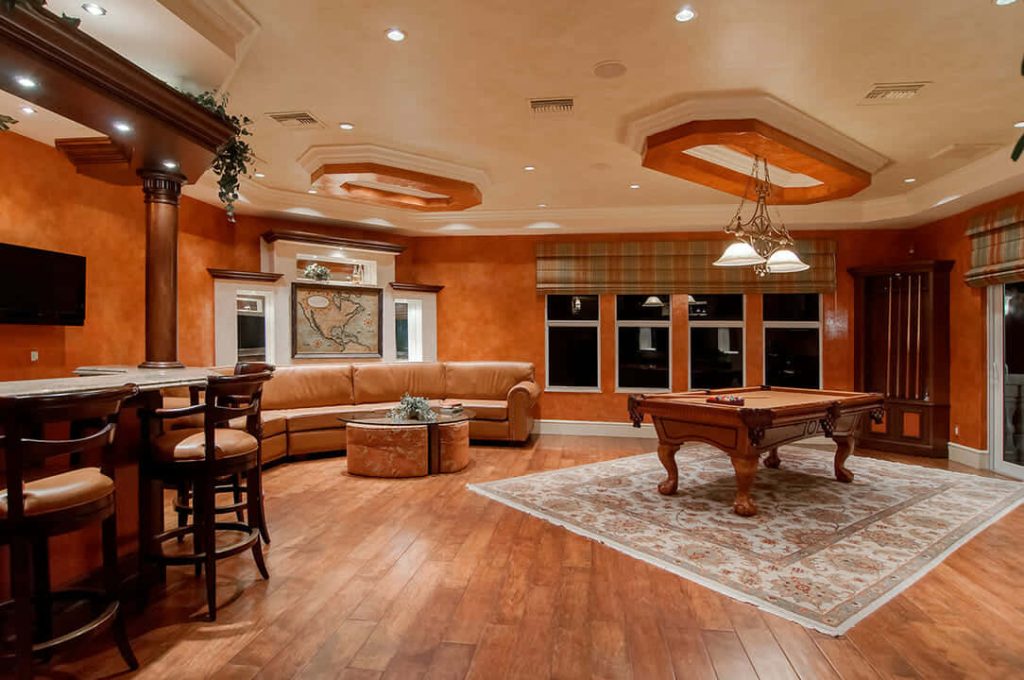 Luxurious home game room Zoom wallpaper with terracotta walls billiard table leather sectional bar