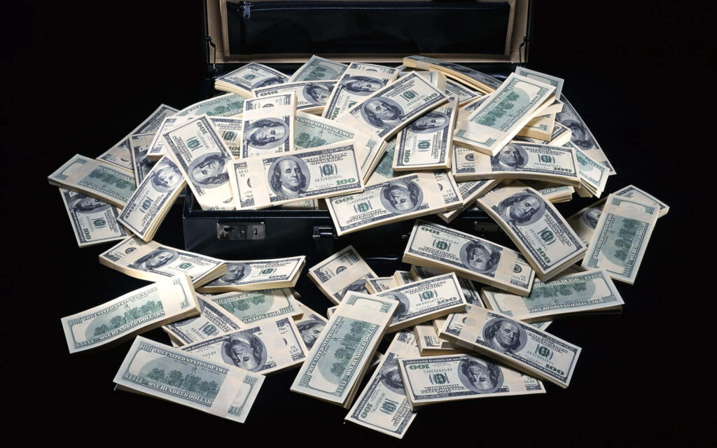 Sleek briefcase overflowing with US dollar bills luxury money desktop wallpaper background