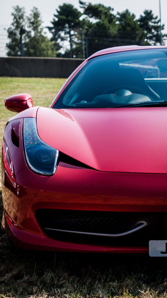 Red Ferrari front bumper with aerodynamic curves luxury car high-end automotive design wallpaper